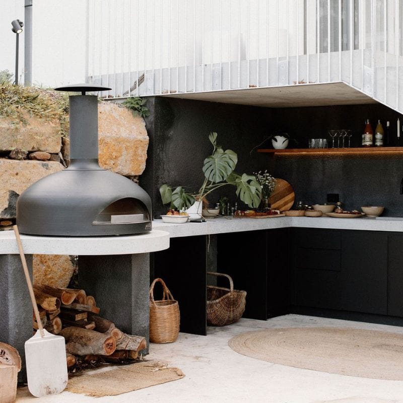 Black Polito Giotto Wood Fired Oven displayed in an outdoor kitchen