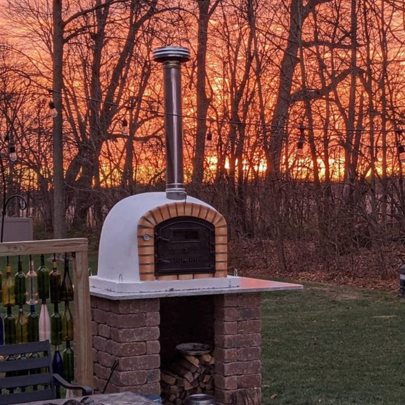 Lisboa Brick Pizza Oven Premium with a stunning sunset behind