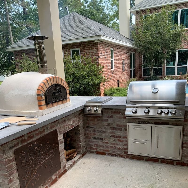 Outdoor kitchen with a pizza oven and a grill