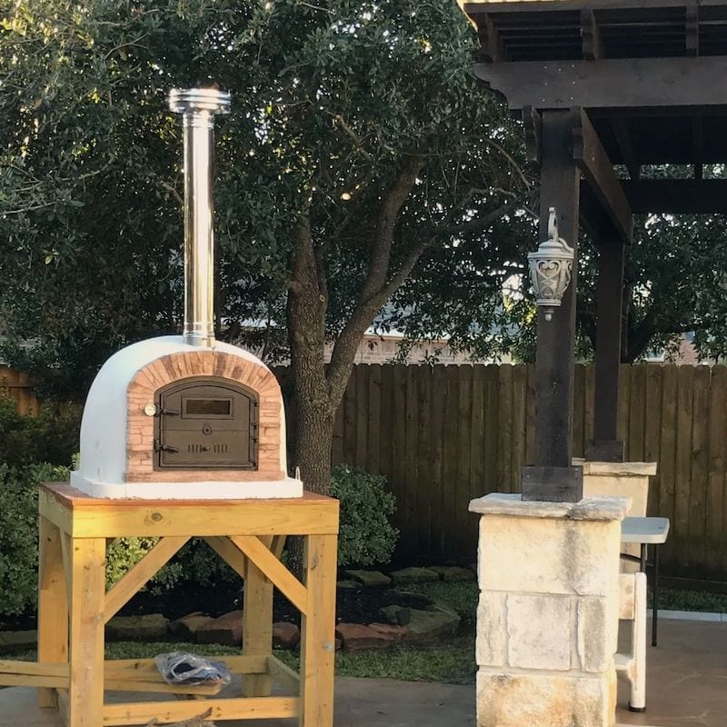 Ventura Sierra Brick Oven set on a DIY wooden stand next to a pergola