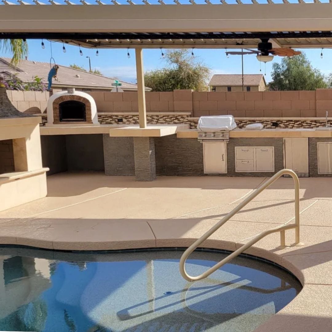 Ventura Sierra Brick Oven set on an outdoor kitchen counter under a pergola by the pool